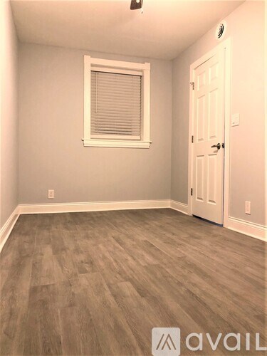 A room with a wooden floor and a white door.