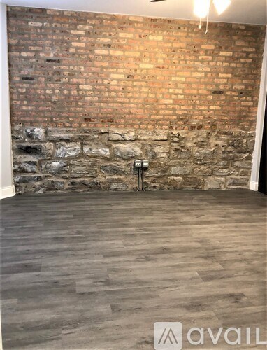 A room with a brick wall and wooden flooring.