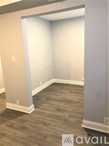 A room with wooden flooring and white walls.