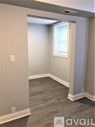 A room with a window and grey walls.
