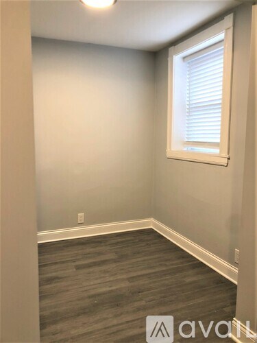 A room with a window and wooden flooring.