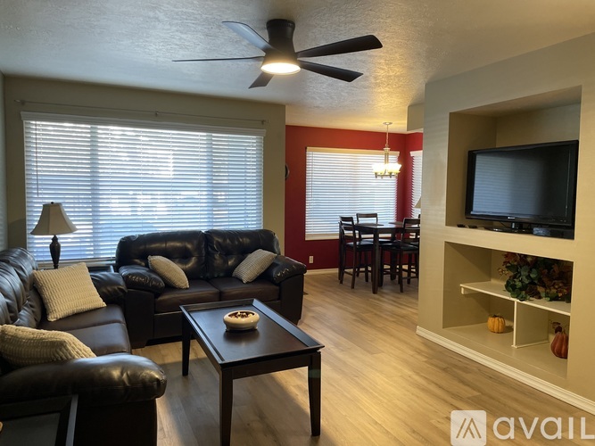 A living room with a black leather couch and a wooden coffee table.