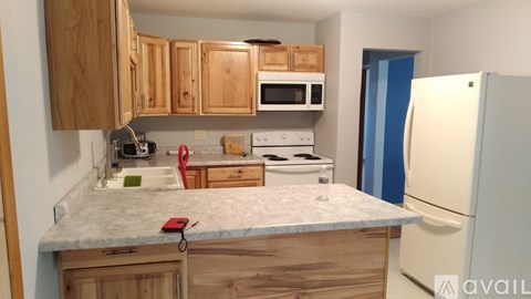 A kitchen with wooden cabinets and a marble countertop.