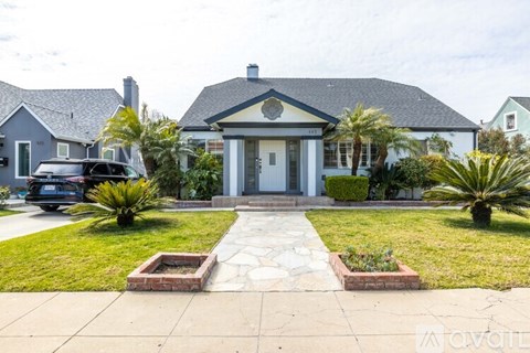 A house with a white front door and a stone pathway leading to it.