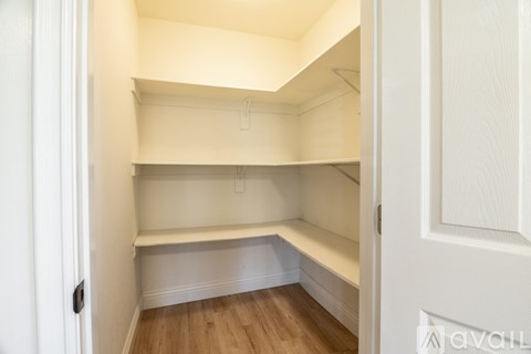 A white pantry with a door on the right.