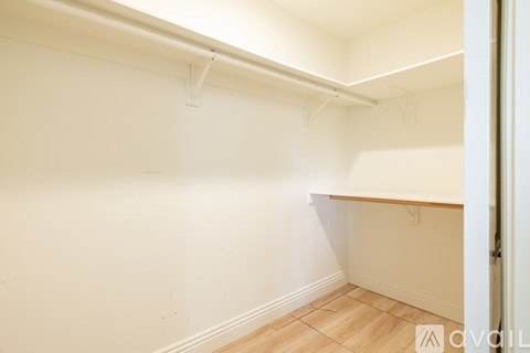 A white wall with a pipe and a wooden floor.