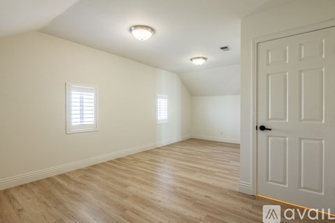A room with wooden flooring and a white door.