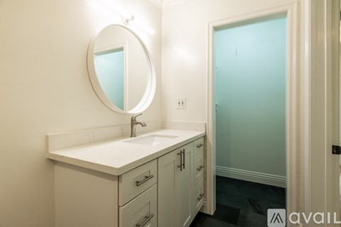 A bathroom with a sink, mirror, and cabinets.