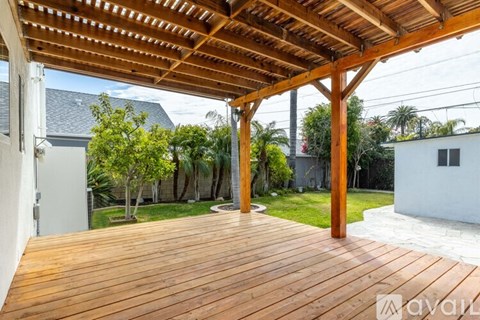 A wooden deck with a pergola over it.