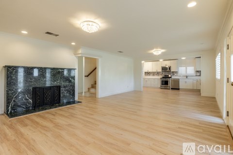 A spacious living room with a fireplace and wooden flooring.