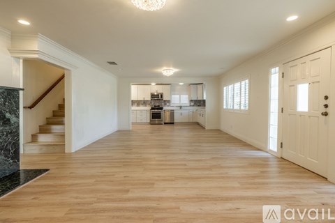 A spacious room with wooden floors and white walls.