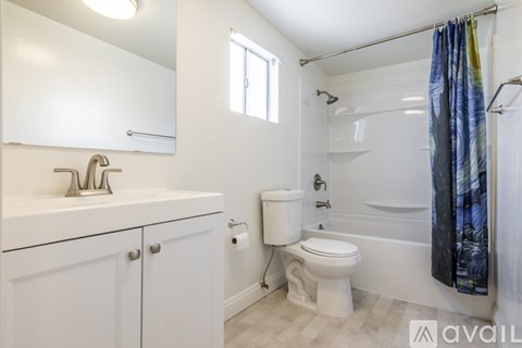 A bathroom with a white toilet, sink, and bathtub.