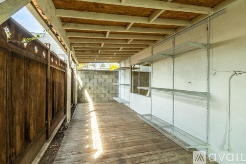 A long, narrow, unfinished room with wooden floors and exposed ceiling beams.