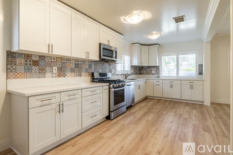 A kitchen with white cabinets and a tiled backsplash.