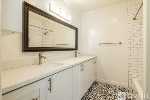 A bathroom with a white sink and a mirror above it.