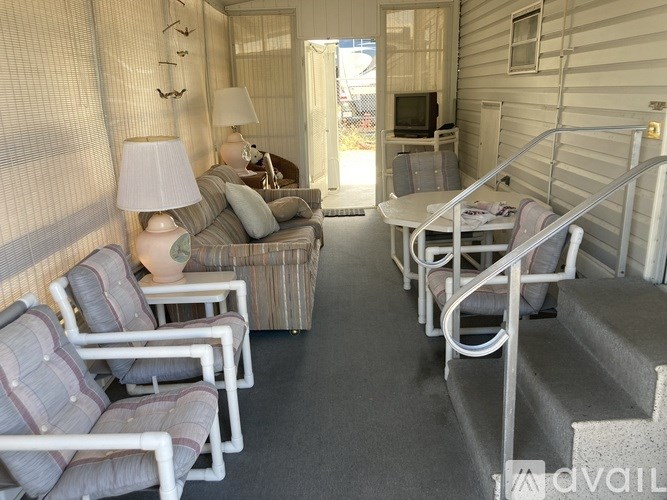 A living room with a couch, chairs, and a television.