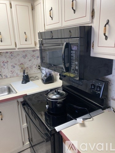 A kitchen with a black microwave and stove.