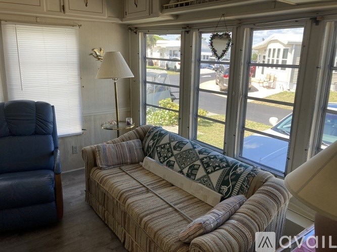 A living room with a blue chair and a striped couch.