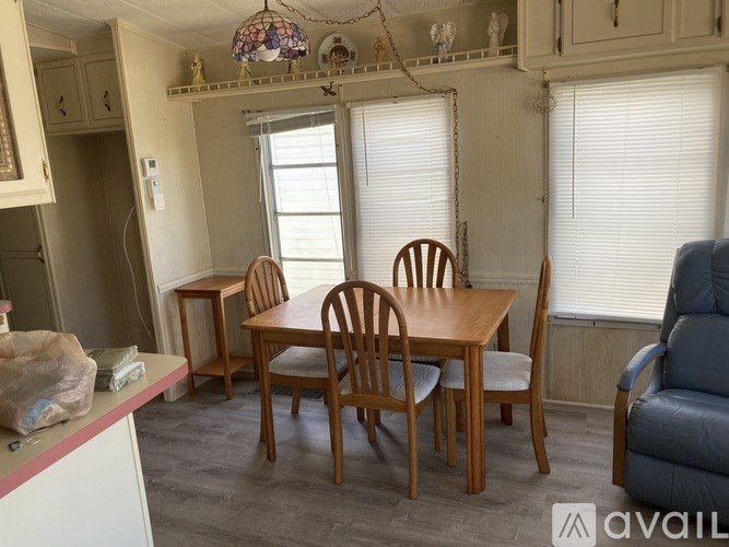 A dining room with a wooden table and chairs.