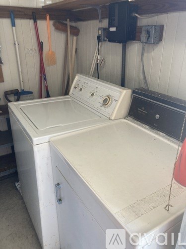 A white washing machine sits in a laundry room.