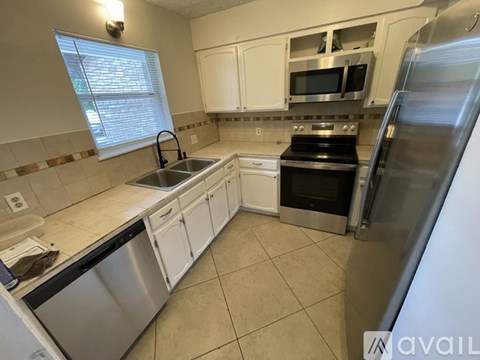 A kitchen with white cabinets and stainless steel appliances.