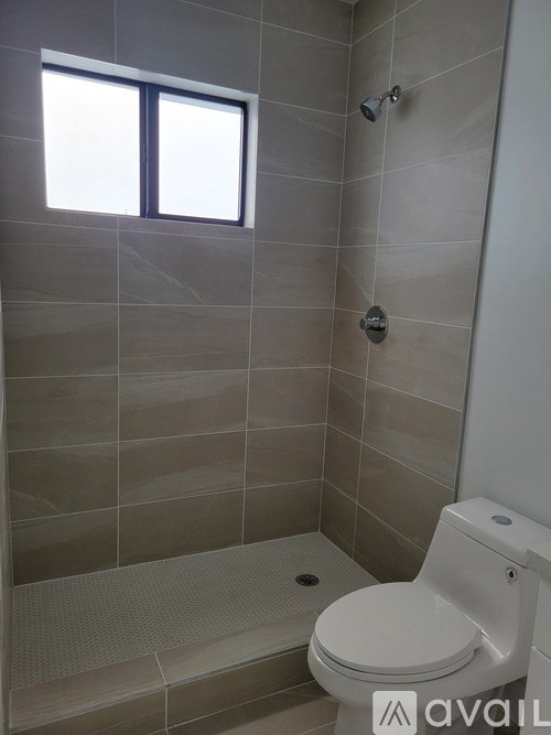 A bathroom with a toilet and a shower.