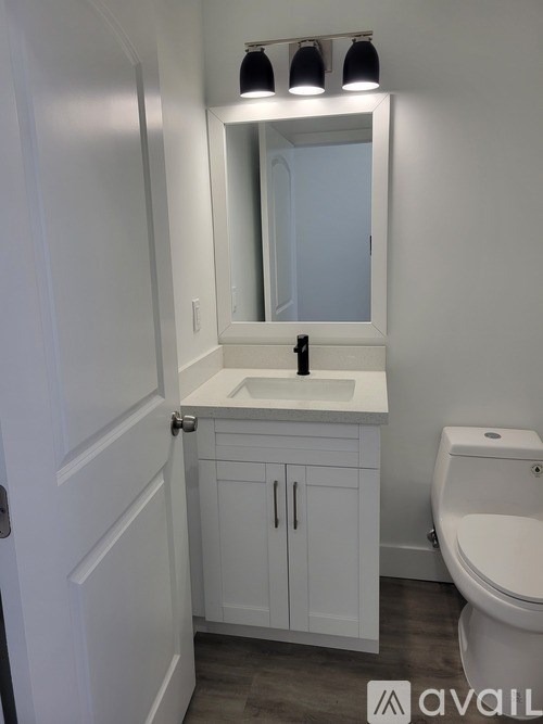 A bathroom with a white sink and toilet.