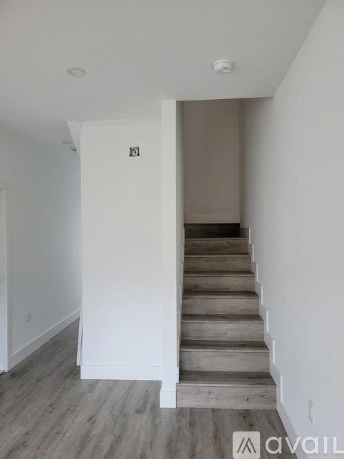 A hallway with a staircase leading to the second floor.