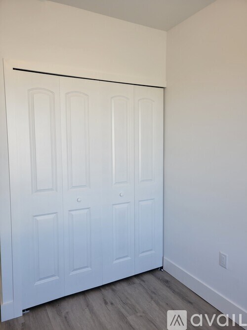 A white door with four panels and a black handle.