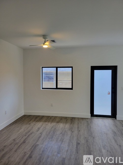 A room with a ceiling fan and two picture frames on the wall.