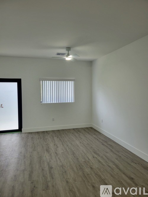 A room with a window and wooden flooring.