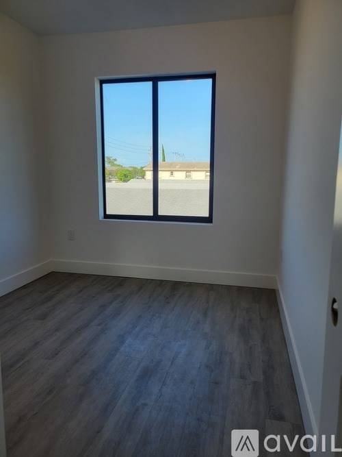 A room with a large window and wooden flooring.