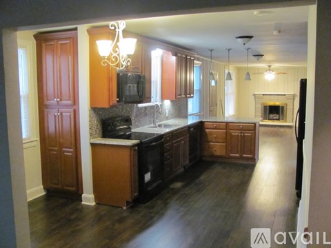 A kitchen with wooden cabinets and a black stove top oven.