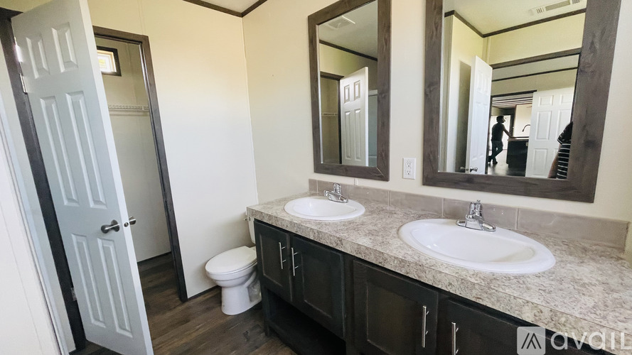 A bathroom with a toilet, sink, and mirror.
