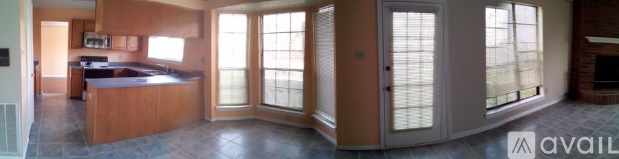 A kitchen with wooden cabinets and a large island with a sink.
