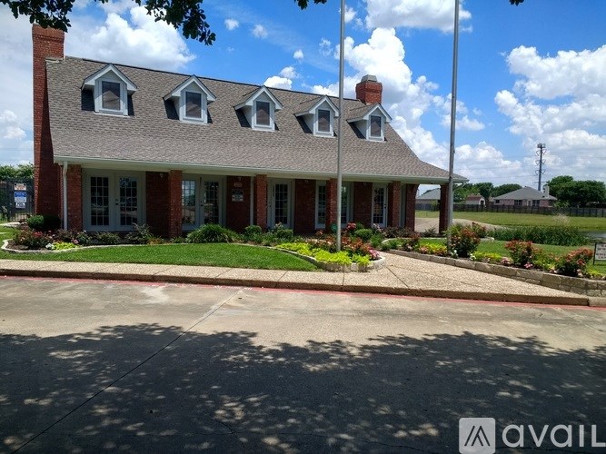 A house with a red brick exterior and a grey roof with white trim.