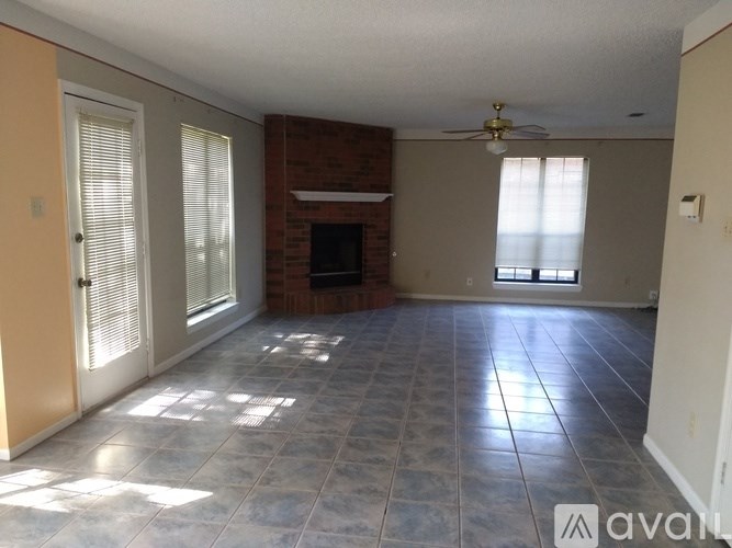 A living room with a fireplace and a fan.