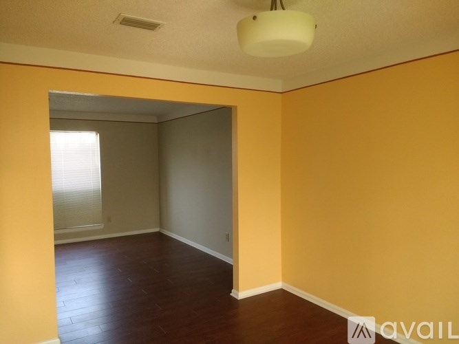 A room with yellow walls and a wooden floor.