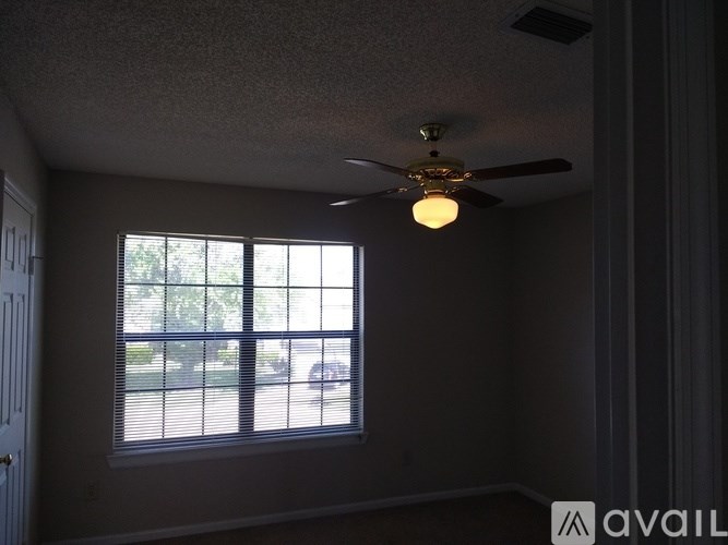 A room with a ceiling fan and a window.