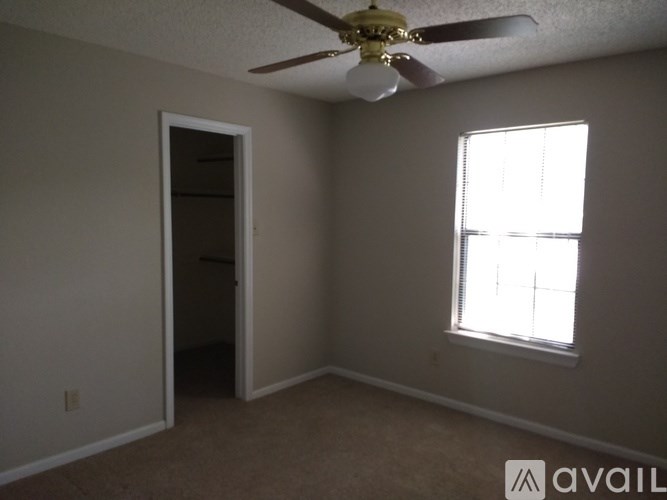 A room with a ceiling fan and a window.