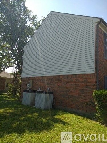 A house with a grey roof and a brick wall with a window and a door.
