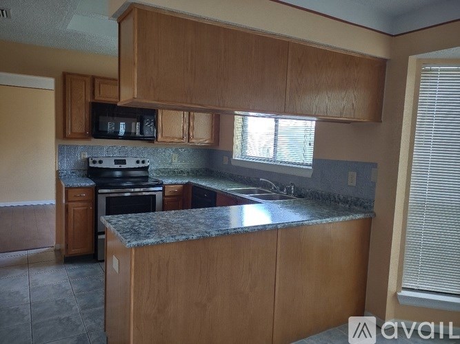 A kitchen with wooden cabinets and a granite countertop.