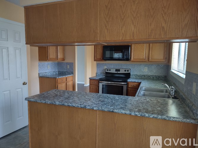 A kitchen with wooden cabinets and a granite countertop.