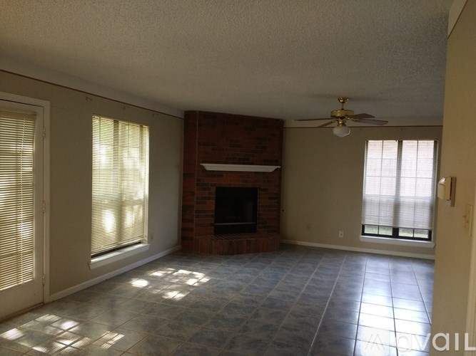 A living room with a fireplace and a ceiling fan.