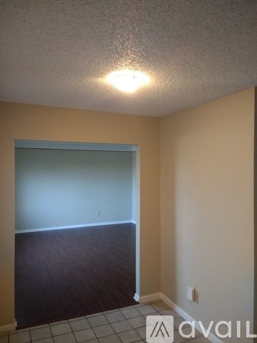 A room with a tiled floor and a doorway leading to another room.