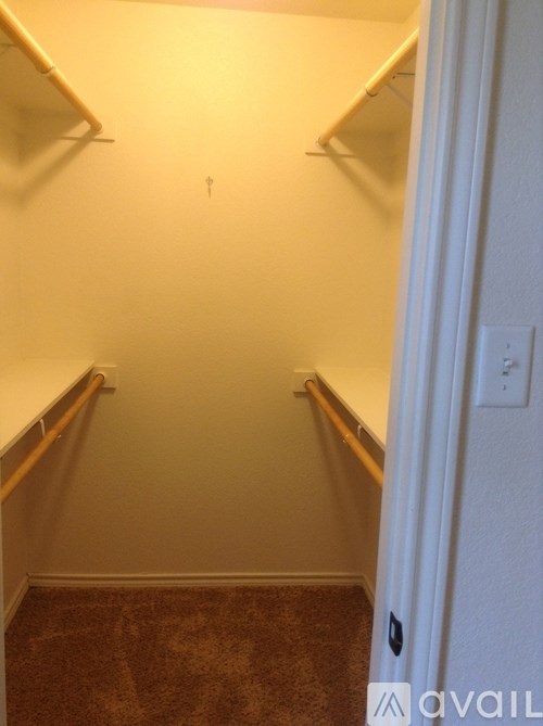 A hallway with a carpeted floor and white walls.
