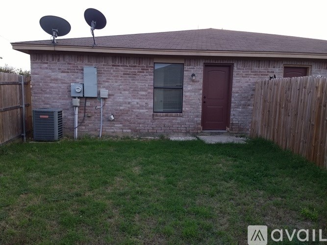 A house with a red door and satellite dishes on the roof.