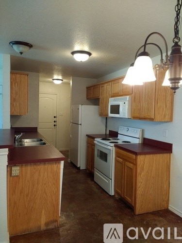 A kitchen with wooden cabinets and a white fridge.
