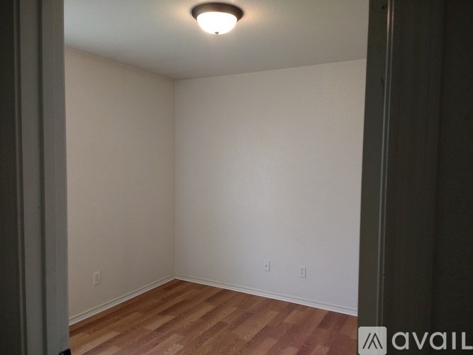 A room with wooden flooring and white walls.