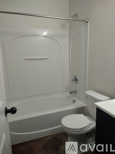A white toilet sits next to a bathtub in a bathroom.